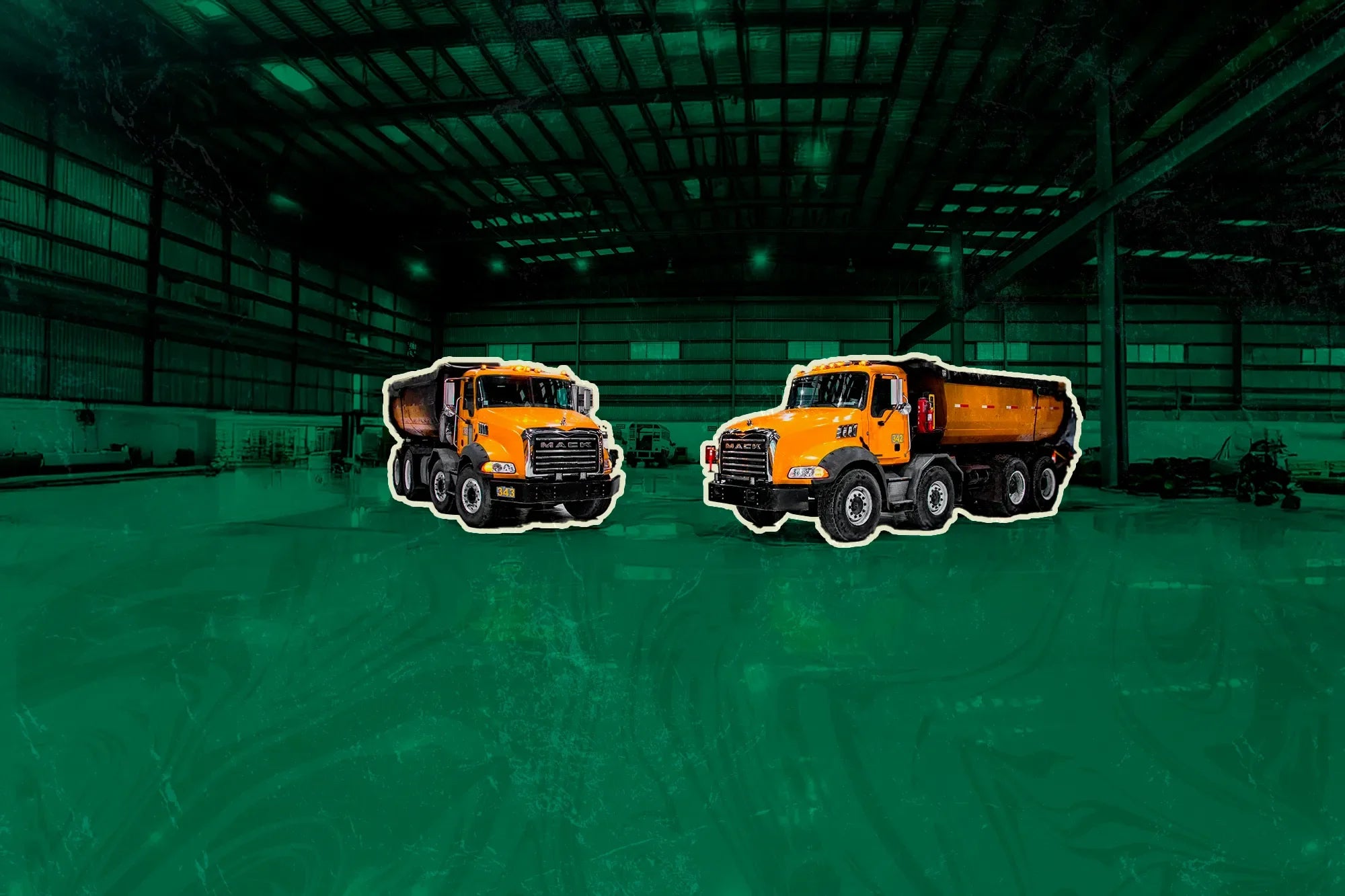 Camiones de volteo Mack Granite seminuevos de color amarillo, en almacén techado.