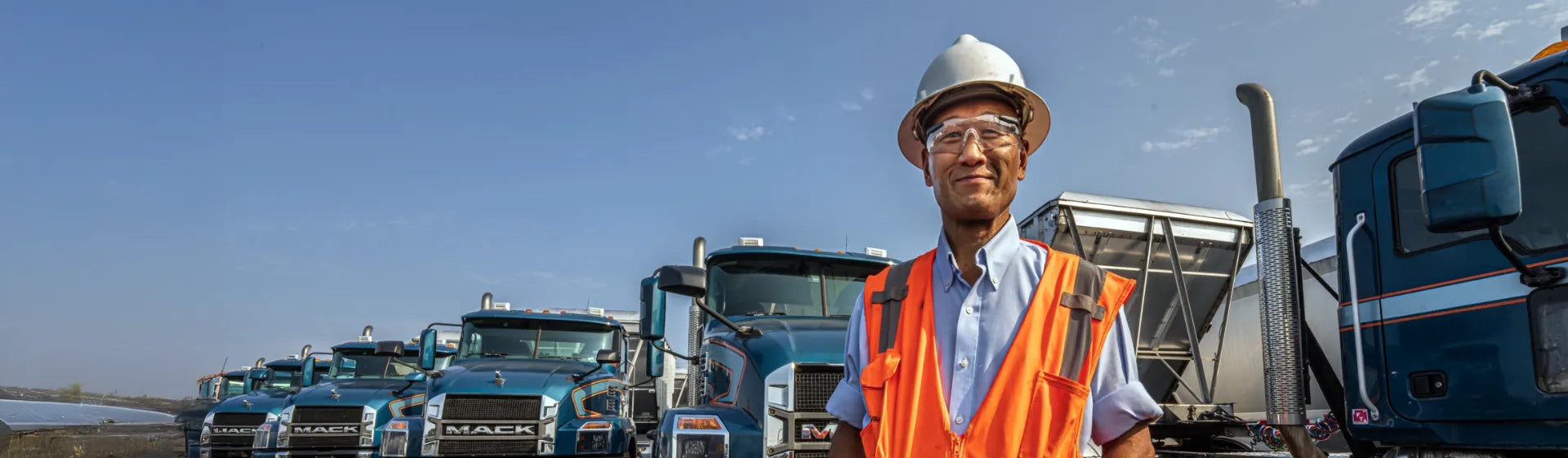Vendedor de refacciones al mayoreo con camiones Mack de fondo